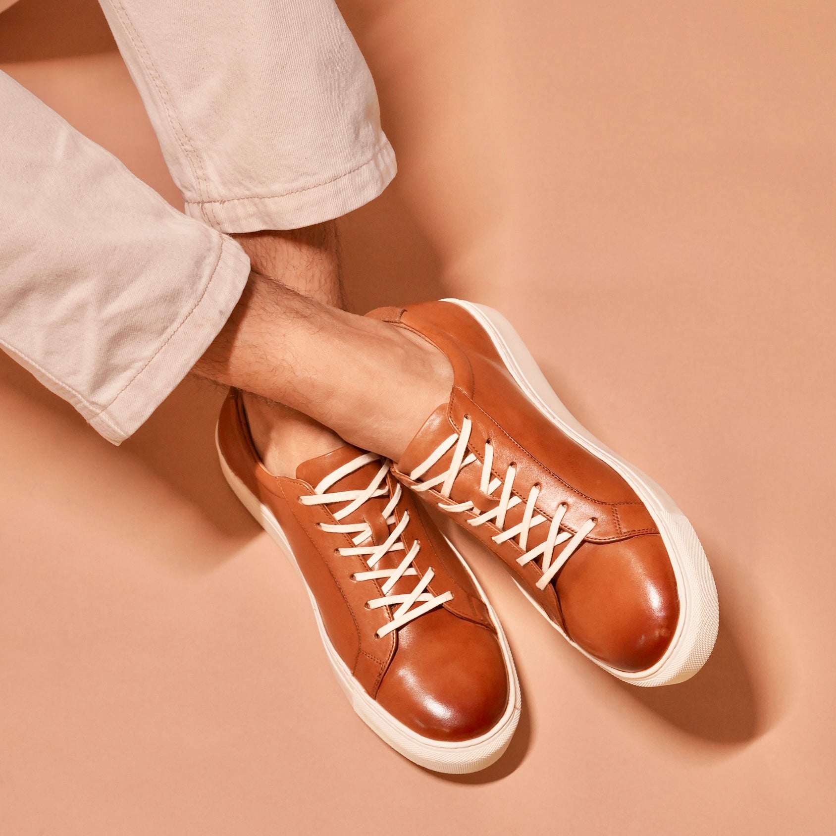 Bosco tan leather sneakers paired with chinos for a versatile look.